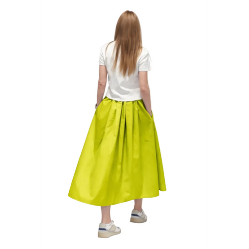 Falda larga de satén verde lima de REVES con cintura plisada y bolsillos laterales. Modelo de espaldas.