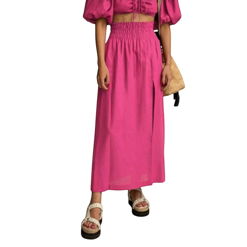 Falda maxi fucsia de REVES con cintura alta elástica y abertura frontal. Tejido ligero.