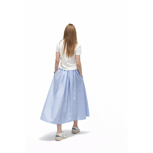 REVES falda Siberia azul claro larga con vuelo y bolsillos, combinada con camiseta blanca y zapatillas.