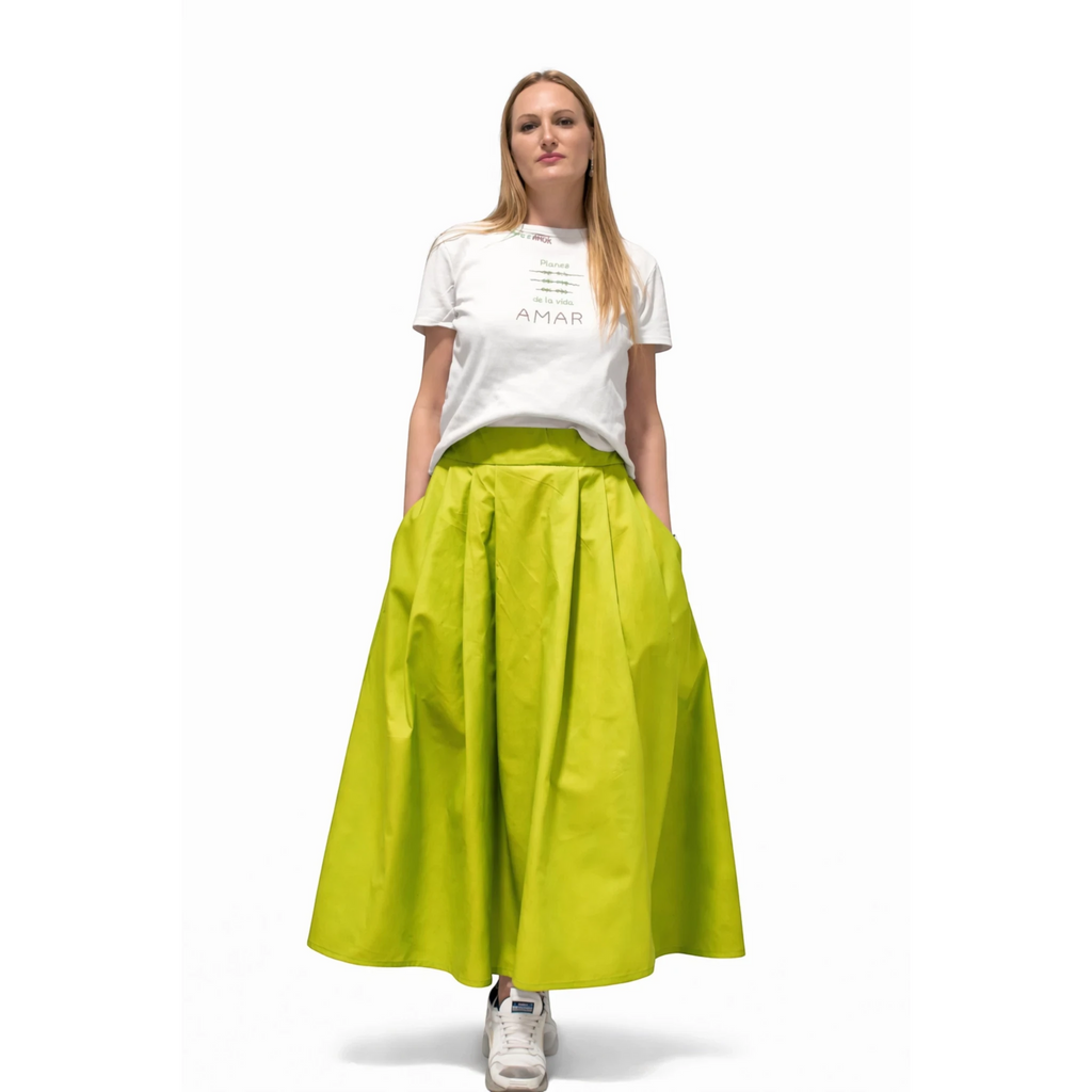 Falda larga de color verde lima de REVES, con bolsillos y vuelo. La modelo lleva camiseta blanca estampada.