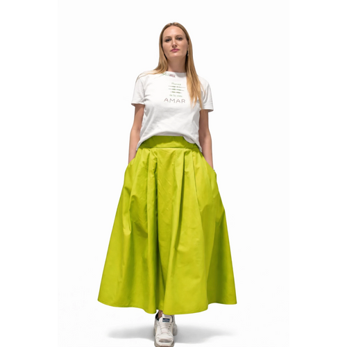 Falda larga de color verde lima de REVES, con bolsillos y vuelo. La modelo lleva camiseta blanca estampada.