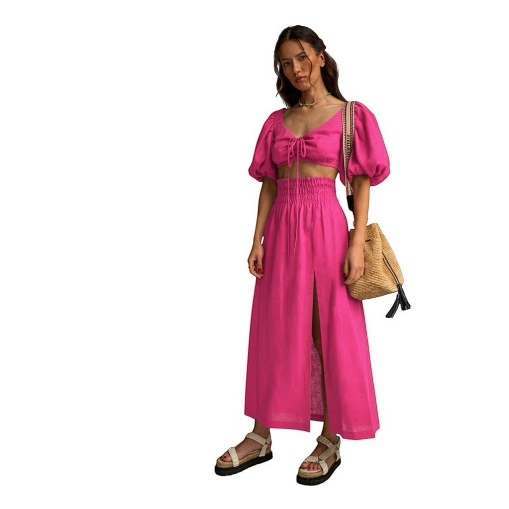 Top fucsia de manga abullonada con lazada frontal y falda larga con abertura lateral de REVES.