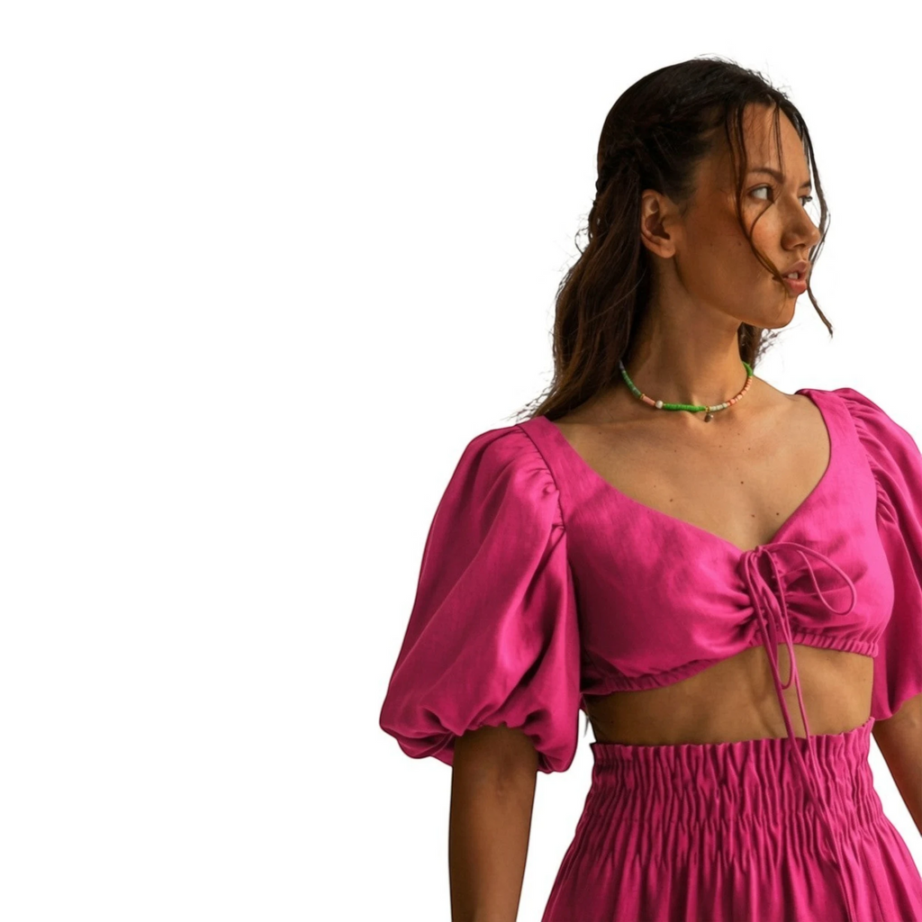 Top fucsia de REVES con mangas abullonadas y escote anudado, ideal para un look atrevido y femenino.