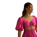 Top fucsia de REVES con mangas abullonadas y escote anudado, ideal para un look atrevido y femenino.
